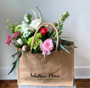 A handed floral bouquet of novelty flower varieties in a hessian Walter Pine tote bag